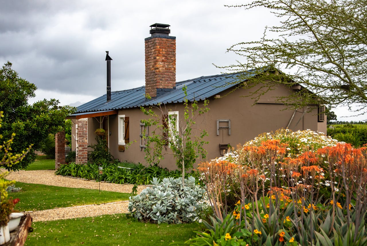 A quaint cottage surrounded by vibrant flowers and greenery, perfect for a countryside retreat.